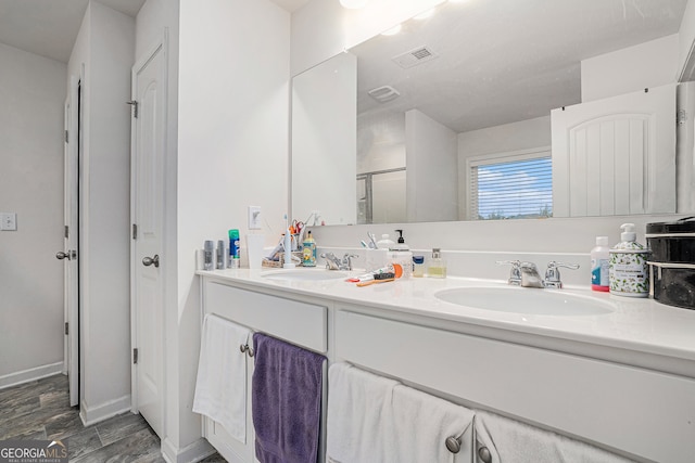 bathroom with walk in shower, wood-type flooring, and vanity