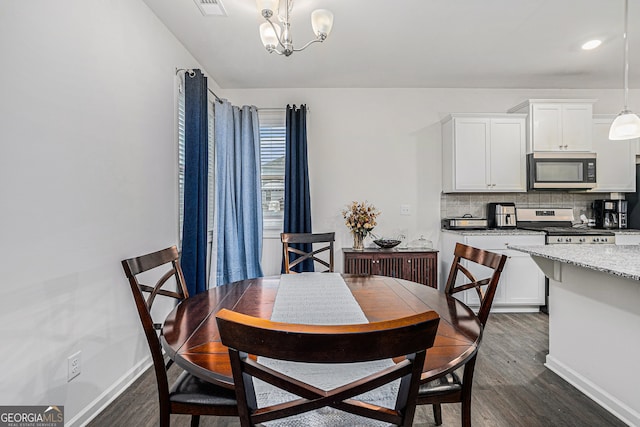 dining space featuring dark hardwood / wood-style floors and a chandelier