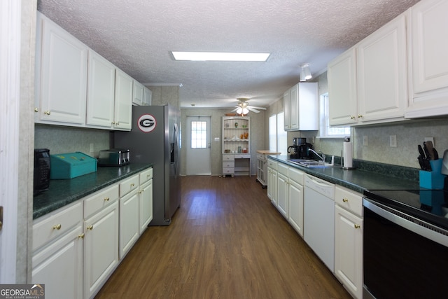 kitchen with appliances with stainless steel finishes, dark hardwood / wood-style floors, a textured ceiling, and white cabinetry