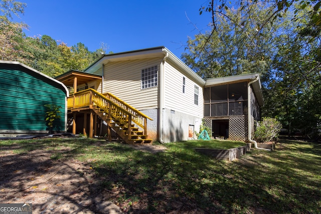 rear view of property with a lawn and a sunroom