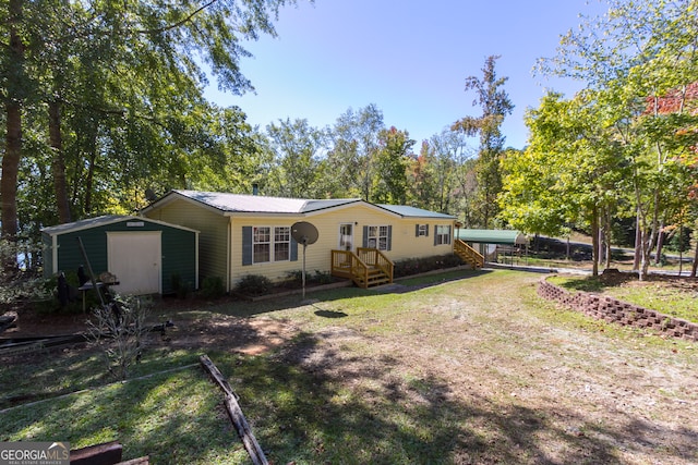 back of property with a yard and a storage shed