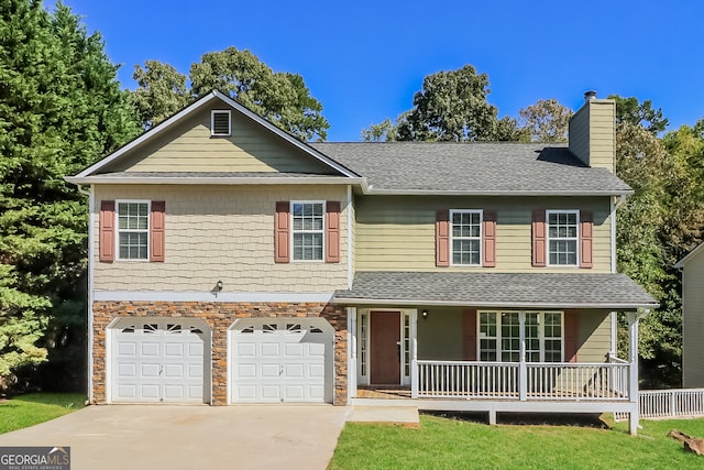 view of front of home with covered porch, a front lawn, and a garage