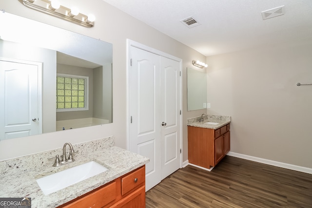 bathroom featuring vanity, hardwood / wood-style floors, and a textured ceiling