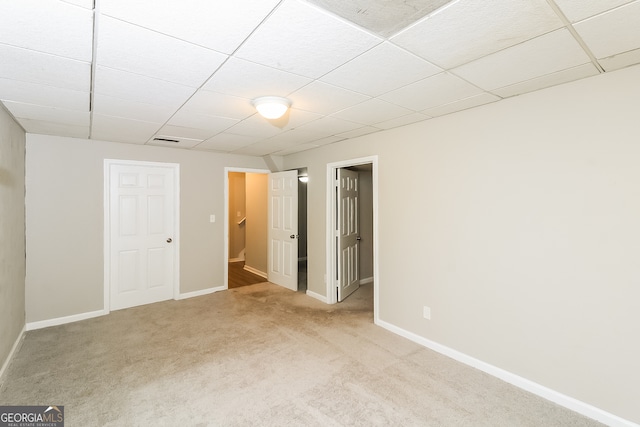 spare room with light colored carpet and a paneled ceiling