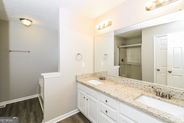 bathroom with vanity, walk in shower, a textured ceiling, and hardwood / wood-style floors