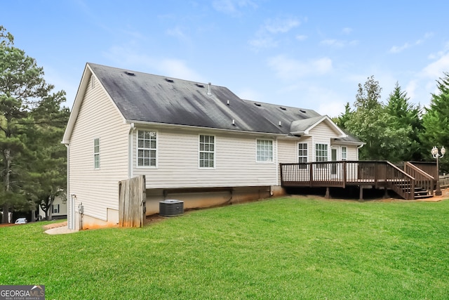 rear view of property with a wooden deck, central AC, and a yard