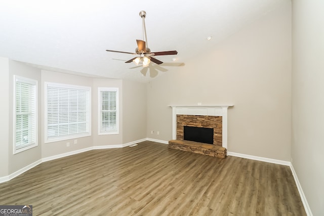 unfurnished living room featuring hardwood / wood-style floors, vaulted ceiling, a fireplace, and ceiling fan