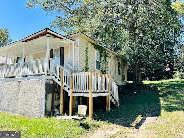 view of side of home with a wooden deck and a yard