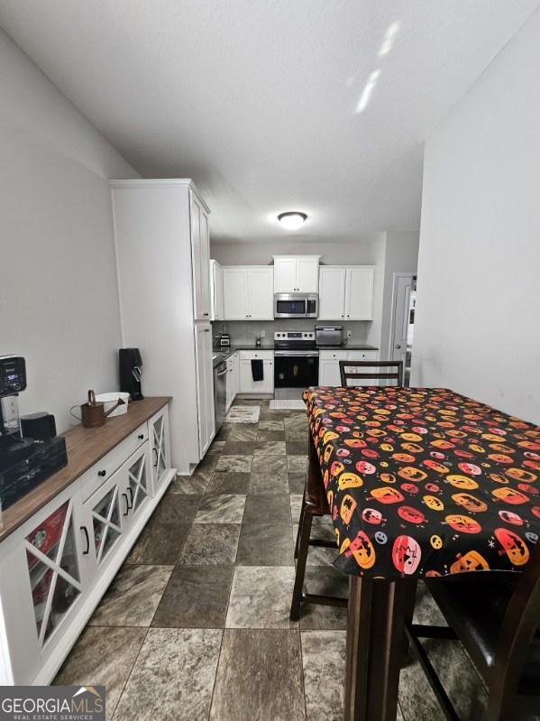 kitchen with stainless steel appliances and white cabinetry