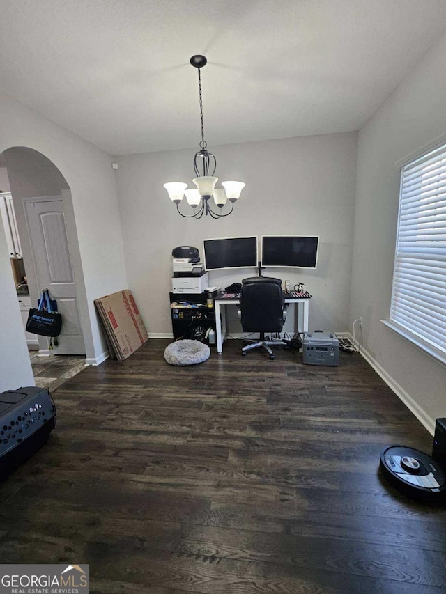 home office with dark hardwood / wood-style floors and a notable chandelier