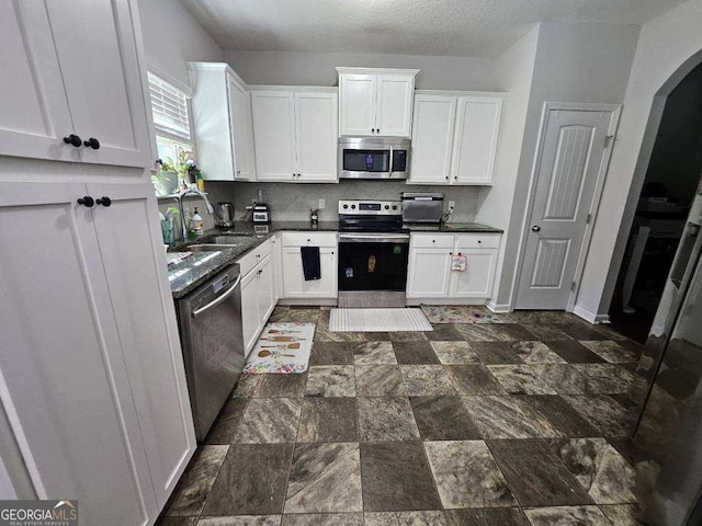 kitchen with white cabinetry, appliances with stainless steel finishes, sink, and a textured ceiling