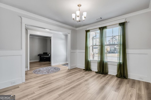 dining room with a chandelier, crown molding, and light hardwood / wood-style floors