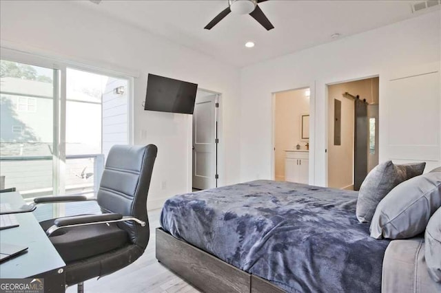 bedroom featuring connected bathroom, multiple windows, light hardwood / wood-style floors, and ceiling fan