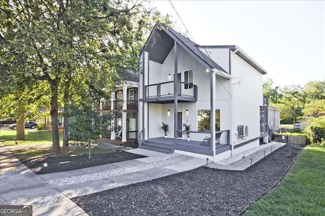 view of property exterior with a porch, a yard, and a balcony