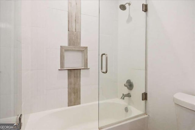 bathroom featuring toilet and enclosed tub / shower combo