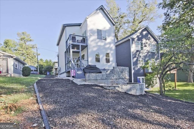 view of front of home featuring a balcony and a front lawn