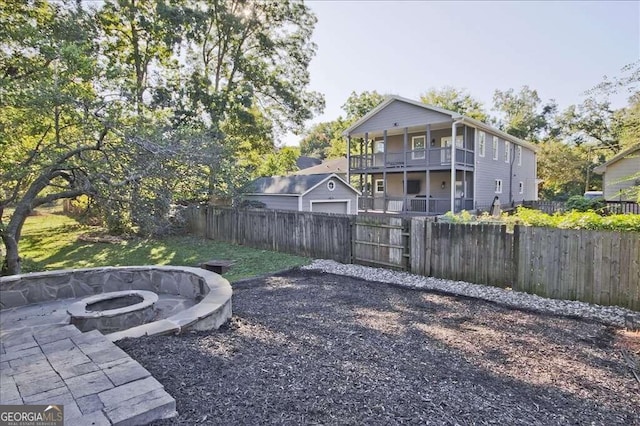 view of yard featuring a fire pit and a balcony