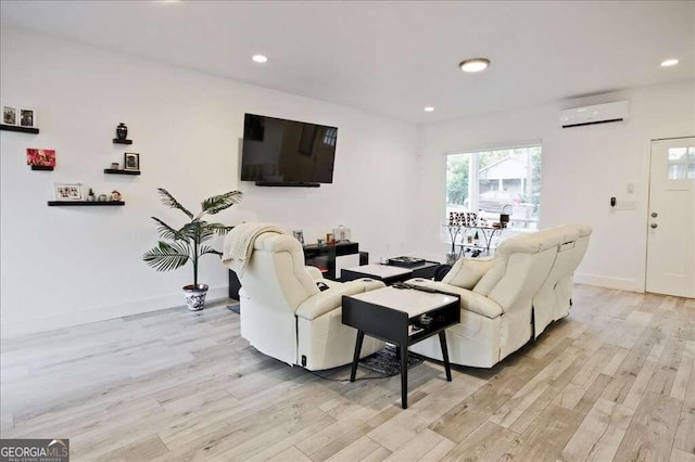 living room featuring a wall mounted air conditioner and light hardwood / wood-style floors