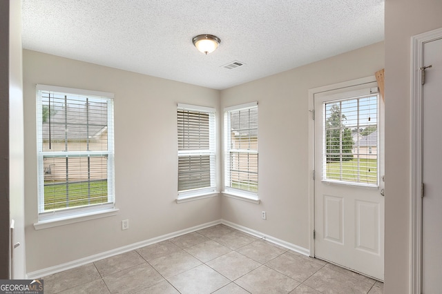 entryway featuring a textured ceiling and light tile patterned floors