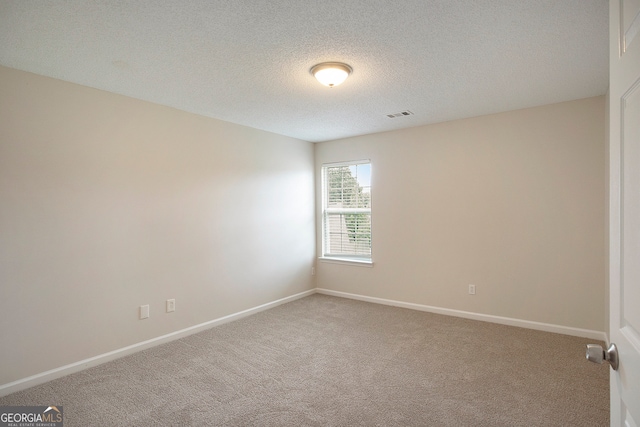 spare room with carpet and a textured ceiling