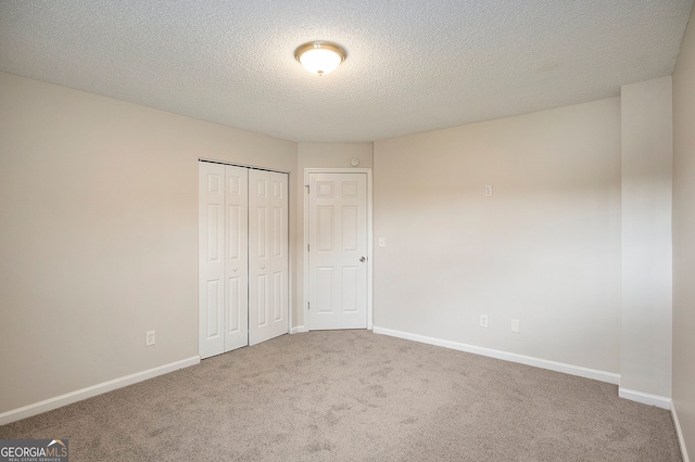 unfurnished bedroom featuring a closet, carpet, and a textured ceiling