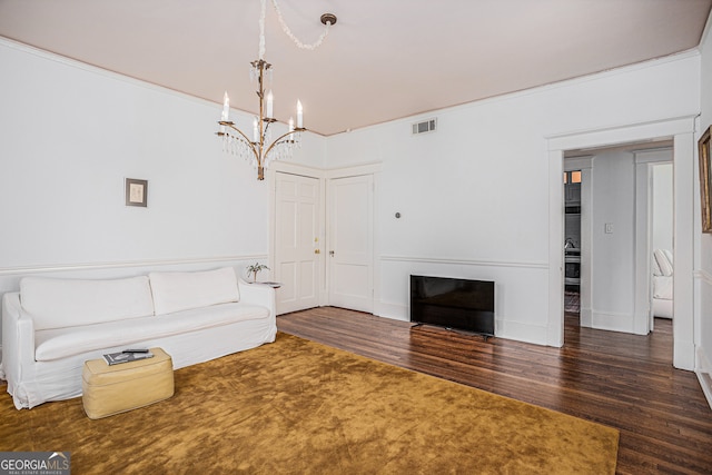 unfurnished living room with crown molding, an inviting chandelier, and dark hardwood / wood-style flooring