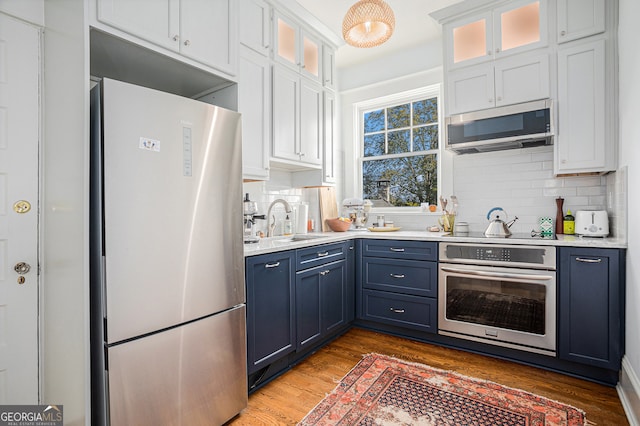 kitchen featuring white cabinetry, stainless steel appliances, sink, and blue cabinets