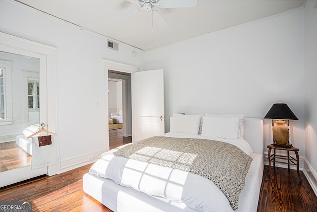 bedroom with hardwood / wood-style floors, ensuite bath, and ceiling fan