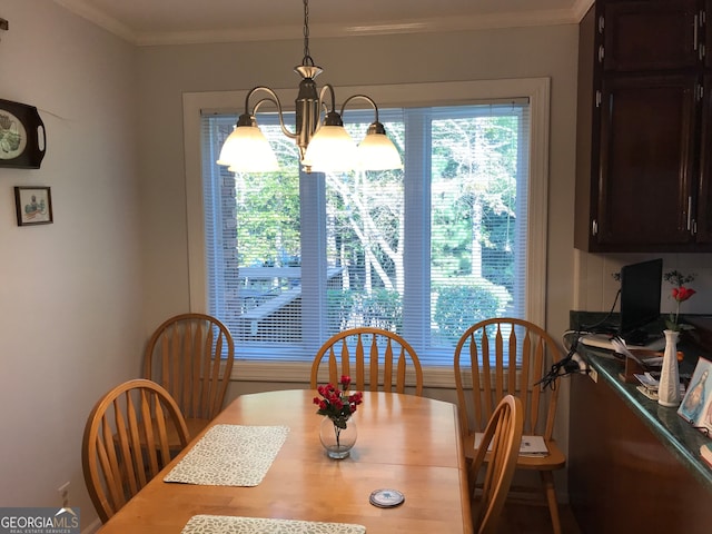 dining space featuring crown molding and an inviting chandelier