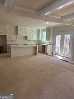 kitchen featuring white cabinets, beamed ceiling, and a center island