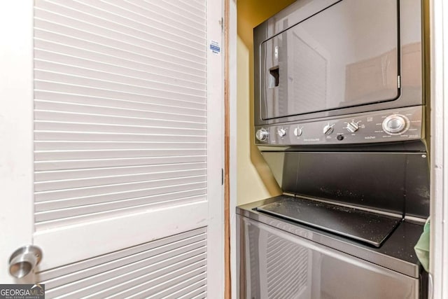 clothes washing area featuring stacked washer and clothes dryer