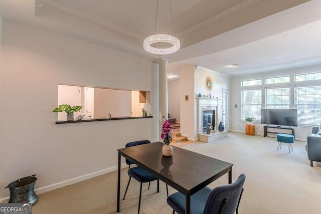 carpeted dining space featuring decorative columns, a raised ceiling, and ornamental molding