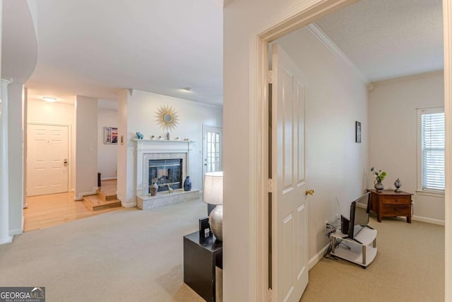 hallway with ornamental molding and light colored carpet