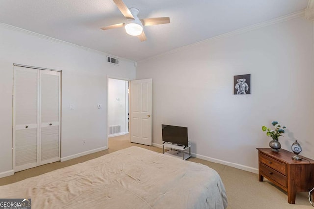 carpeted bedroom with a closet, ornamental molding, and ceiling fan