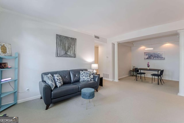 carpeted living room featuring crown molding and decorative columns