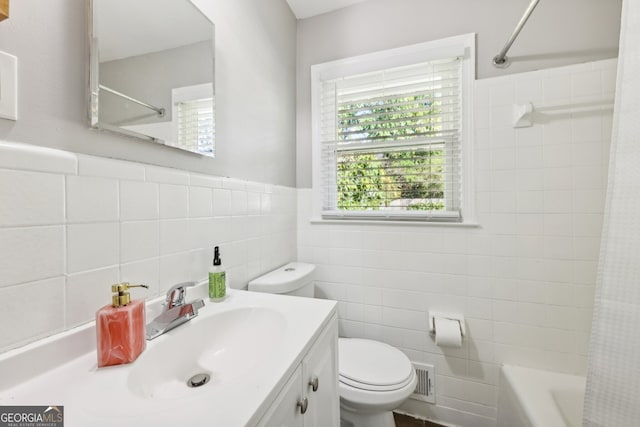 full bathroom with vanity, toilet, tile walls, and shower / bath combo with shower curtain