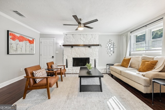 living room featuring a fireplace, wood-type flooring, crown molding, a textured ceiling, and ceiling fan