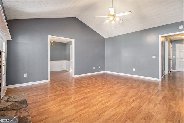 unfurnished living room featuring ceiling fan, a textured ceiling, light wood-type flooring, and lofted ceiling