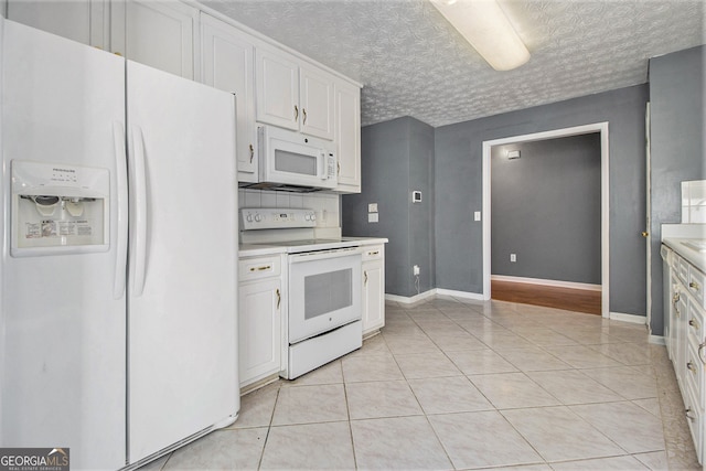 kitchen with white cabinets, a textured ceiling, tasteful backsplash, light tile patterned floors, and white appliances