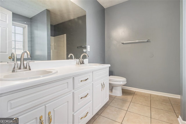 bathroom featuring toilet, vanity, a textured ceiling, and tile patterned floors