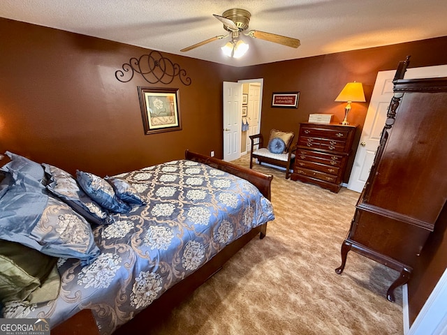 carpeted bedroom featuring ceiling fan and a textured ceiling