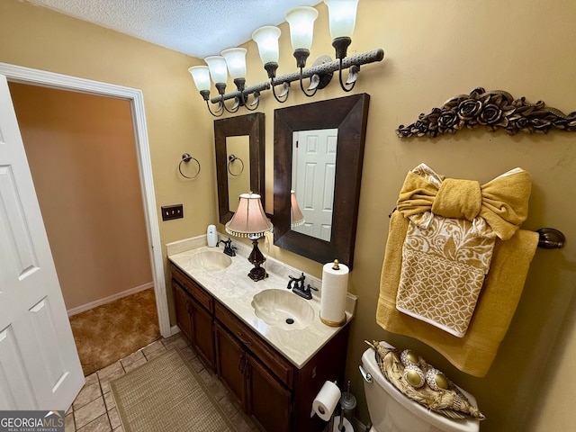 bathroom with toilet, a textured ceiling, and vanity