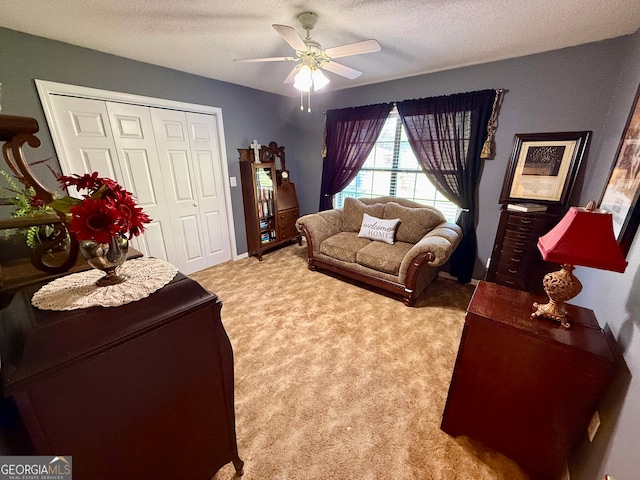 carpeted living room featuring a textured ceiling and ceiling fan