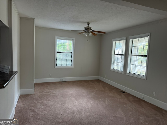 unfurnished room with crown molding, light carpet, a textured ceiling, and ceiling fan