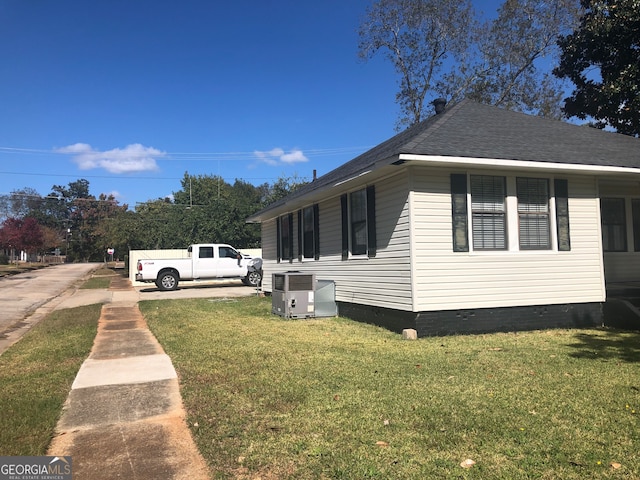 view of side of home with a yard and cooling unit