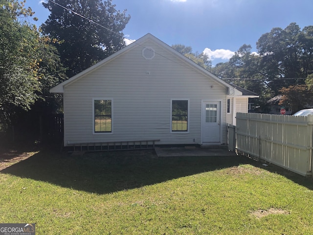 back of property featuring a lawn