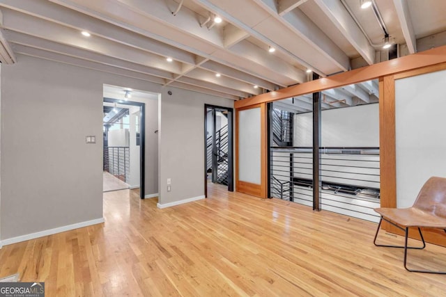 interior space with beamed ceiling and light hardwood / wood-style floors