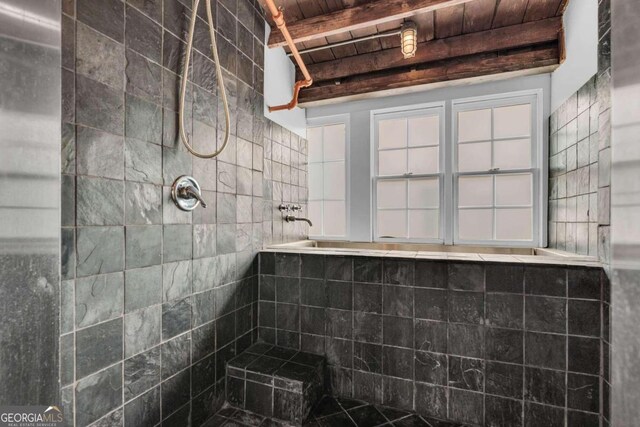 bathroom featuring beamed ceiling, wood ceiling, and tiled shower