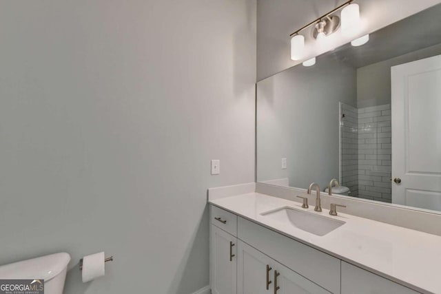 bathroom with baseboards, vanity, toilet, and a shower