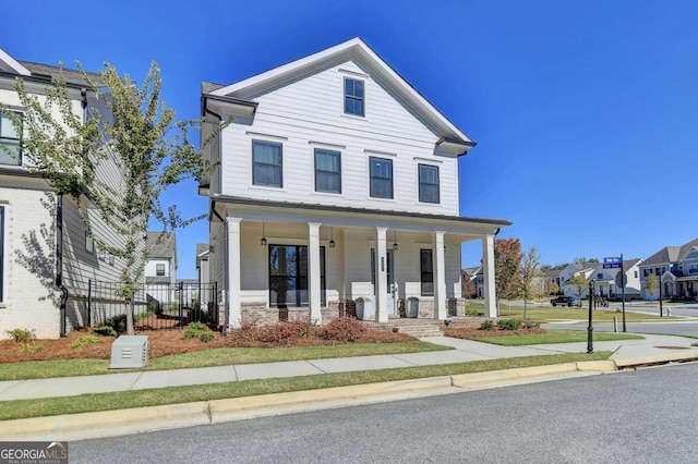 view of front of home featuring fence, a residential view, and covered porch